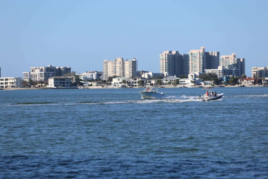 Boats cruising on Clearwater Bay with the city skyline in the background