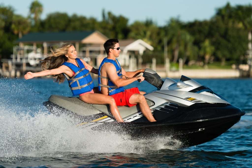 Two people riding a personal watercraft on the water near Clearwater